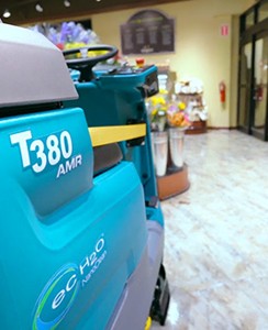Tennant Company robotic floor scrubber cleaning grocery store without a driver on auto pilot. The floor cleaning machine uses LIDAR technology to navigate around objects and people safely.